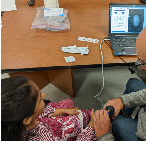 fingerprints are being collected from children using a commercial scanner.