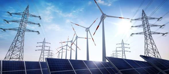 Solar panels line the bottom of the image, with power lines and wind turbines in the background against a blue sky. 