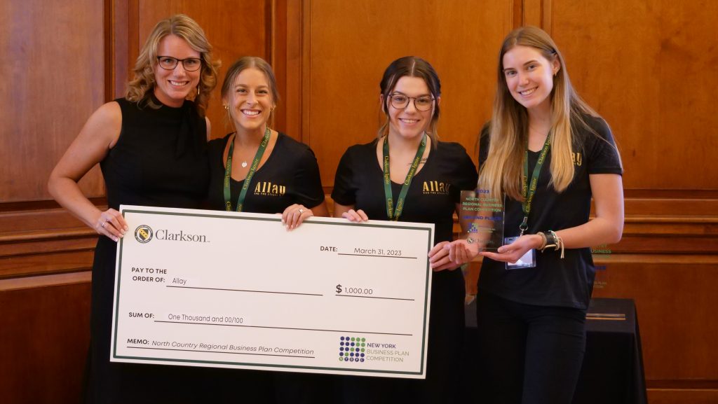The photo features a student-run business, Allay, being presented with a second place prize check for $1000 during last year's North Country Regional Business Plan Competition.