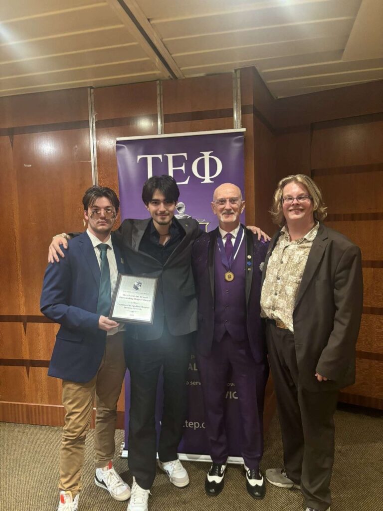 Members of TEP stand with their International Consul after receiving the Charles M Driesen Outstanding Chapter Award.