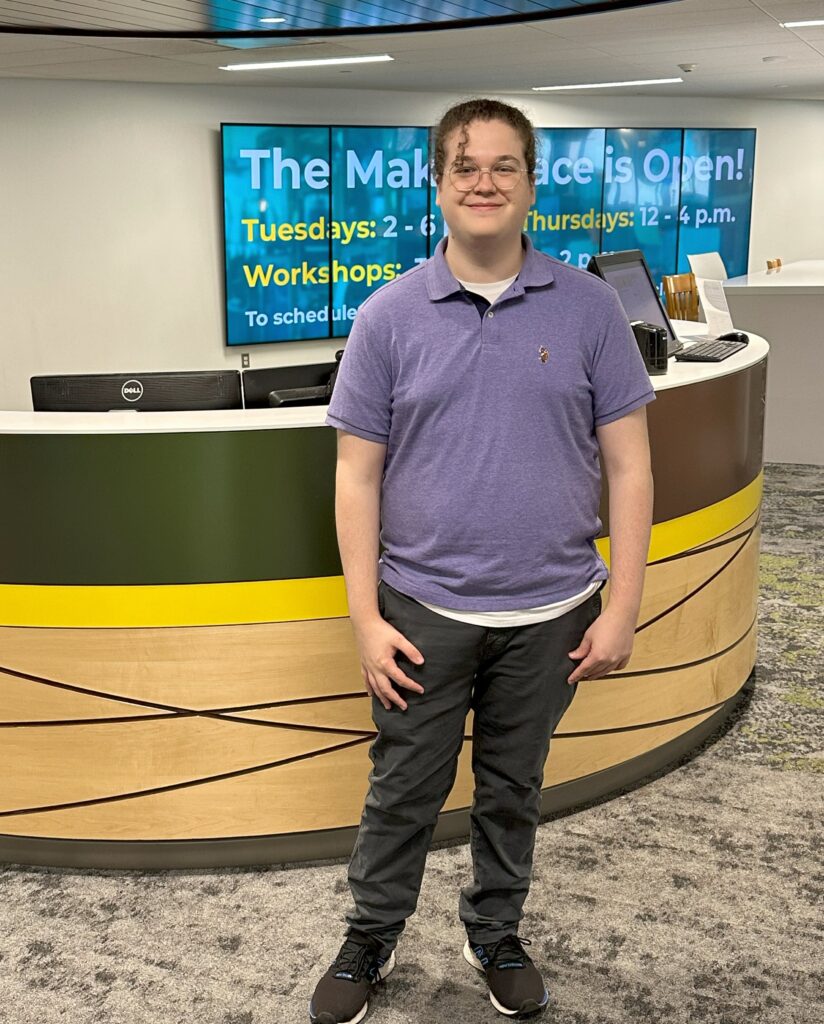 Theo Cannamela standing in front of Help Desk in ERC