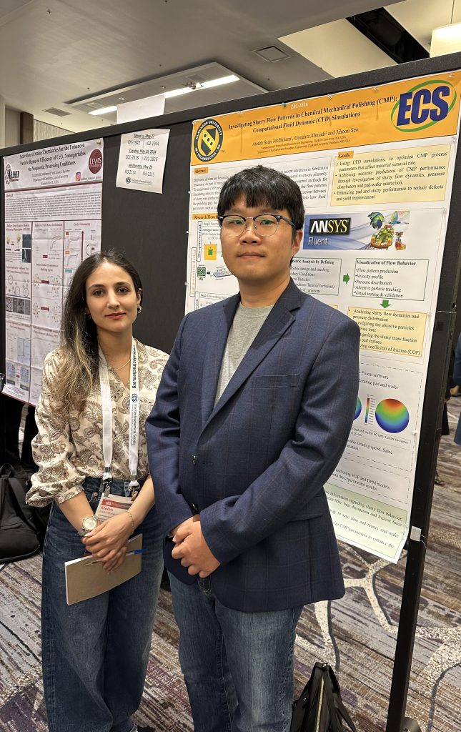 Atefeh Sadri Mofakham poses in front of a scientific poster with a male colleague.