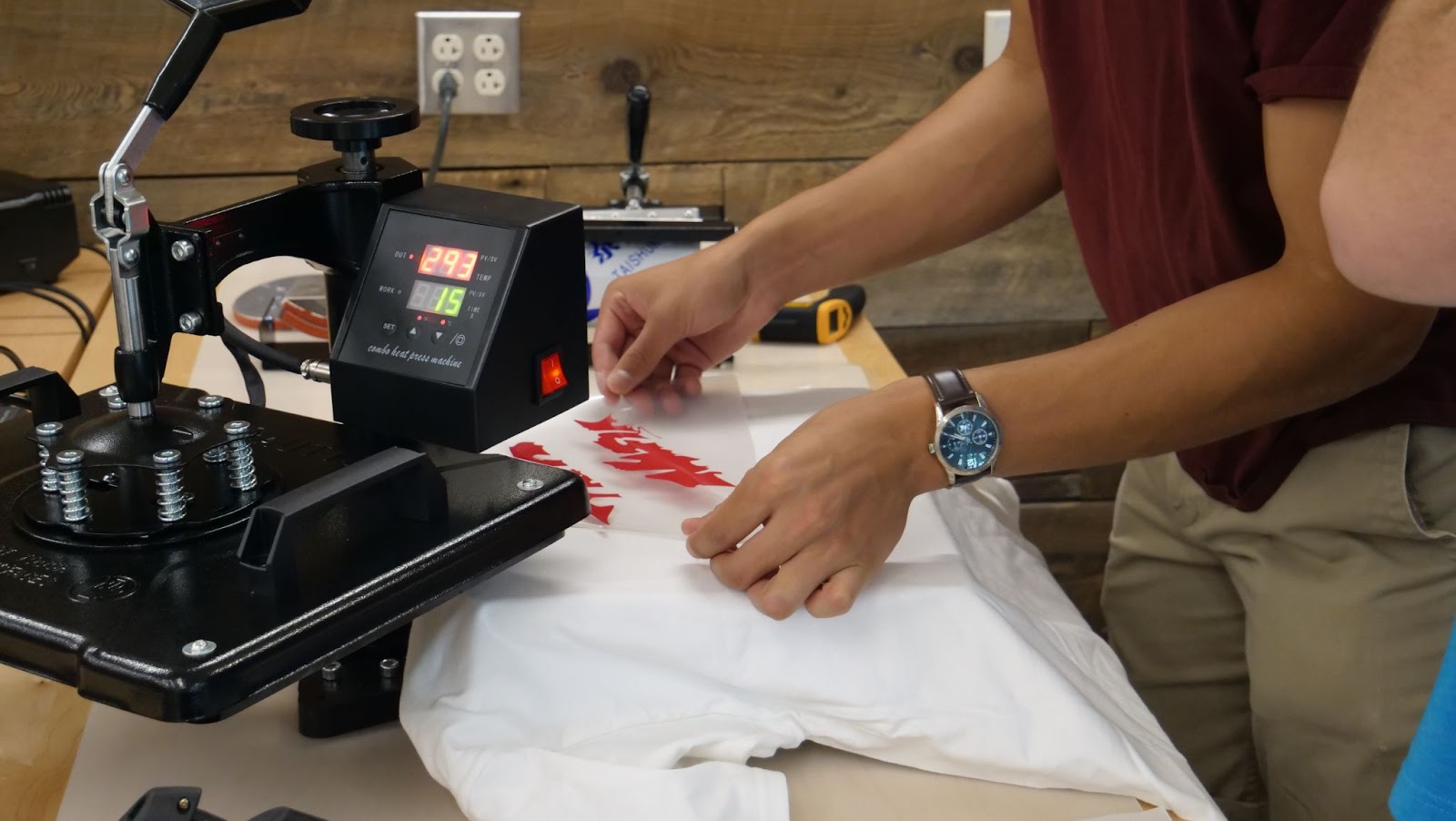 a student placing a vinyl-cut design onto a t-shirt in the Makerspace.