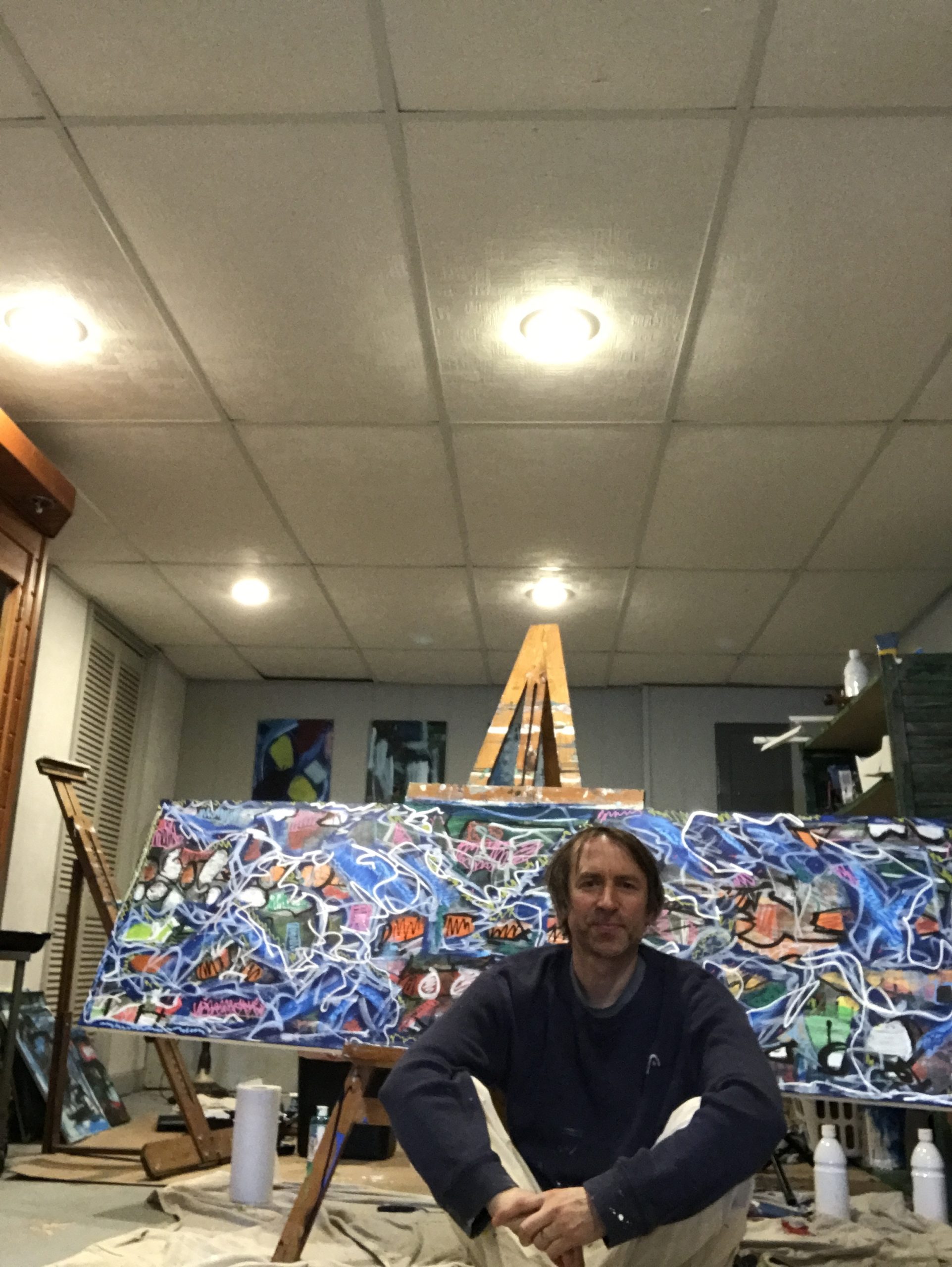 portrait of Jason Schmitt with his artwork in the background